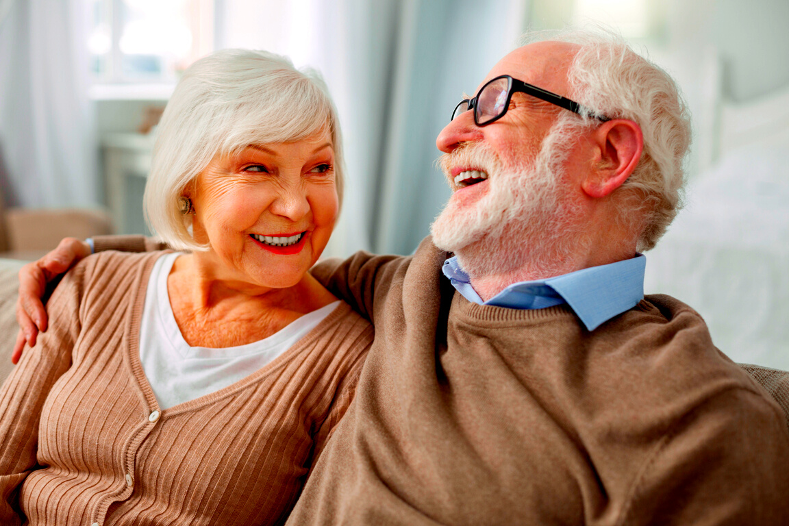 Cheerful elderly man hugging his wife